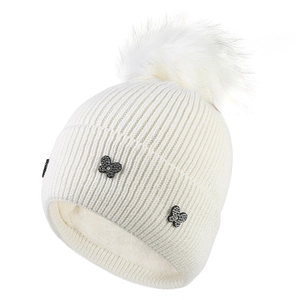 White cable knit beanie with faux fur pom and butterfly accents, warm fleece lining