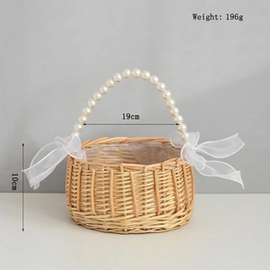 Detail of hand-woven wicker flower basket with pearl handle and white ribbon bows