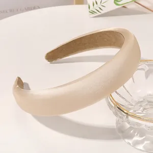 Detailed close-up of white satin sponge headband with non-slip velvet inner lining