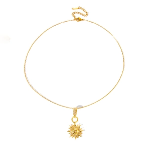 Detail of gold sun pendant necklace featuring sparkling zircons and S-STEEL engraved clasp