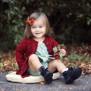 Gros plan d'une pince à cheveux avec nœud rouge et renne doré pour enfant à Noël