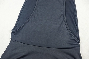 Detail of black sleeveless dress showing the elastic knit fabric and waist seam stitching