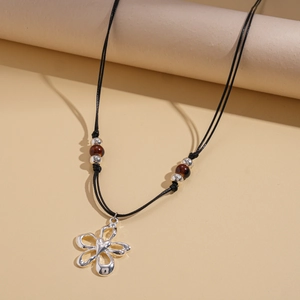 Détail du pendentif fleur argentée sur collier en cordon noir avec des perles