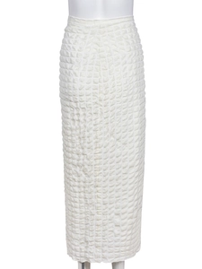 Detailed close-up of white popcorn texture fabric with 3D square pattern on long skirt