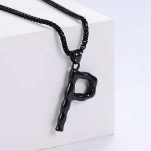 Détail macro du pendentif lettre P noir en 3D avec texture lave sur acier titane