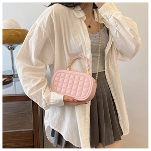 Detail of pink quilted box bag with braided handle and gold chain shoulder strap