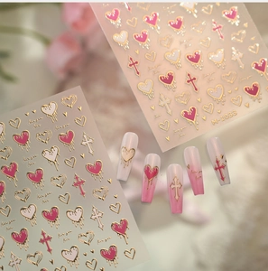 Detail of pink and gold heart nail stickers with embossed crosses and 3D textures