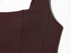 Close-up of wine red knitted dress fabric showing vertical seams and texture detail