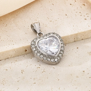 Macro detail of silver heart pendant with large crystal and small diamonds on stone