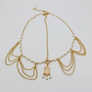 Detail of gold multilayer chain headpiece with faux pearls and sparkling rhinestone pendant