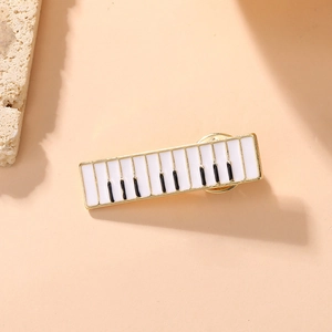 Detailed view of a piano key enamel brooch with gold-tone plating and a clutch back pin