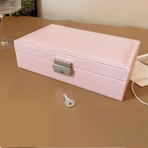 Makroansicht der rosa Schmuckschatulle mit Kreuzmaserung und silbernem Schloss mit Schlüssel