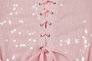 Detail aus rosa Mesh-Gewebe mit silbernen Pailletten und Schnürung mit Metallösen