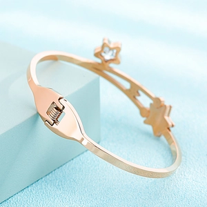 Detailed macro view of rose gold star bracelet featuring a spring clasp and crystal inlay