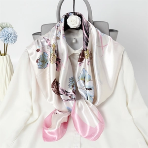 Fashionable floral silk scarf in pink and white tied on a blouse with professional styling