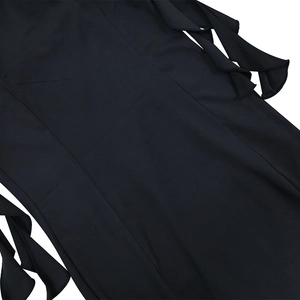 Détails de la robe noire avec des volants superposés et des coutures verticales précises