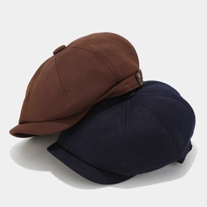 Detail of retro newsboy caps in caramel brown and navy with leather side strap