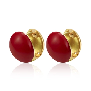 Detailed close-up of golden heart hoop earrings with vibrant red enamel finish