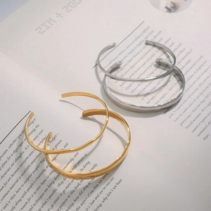 Minimalist irregular wave open bangle in gold and silver finish with polished stainless steel