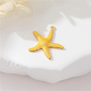 Macro view of gold starfish pendant with textured surface on a white stone base
