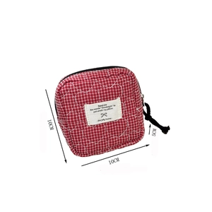 Detailed view of red plaid sanitary pouch with heart quilting and 10x10x5cm size labels