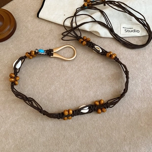 Detail view of handmade bohemian waist chain with wood beads and shell accents