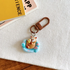 Detail of cute brown bear keychain on blue sofa base with metallic lobster clasp
