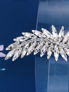 Close-up of elegant leaf-shaped hair clip with silver base and sparkling rhinestones