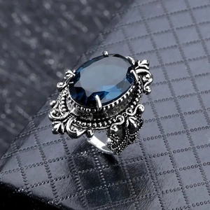Anello vintage in stile reale con grande gemma blu ovale e dettagli in rilievo decorati