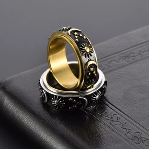 Vintage stainless steel spinner rings featuring celestial sun and moon relief patterns