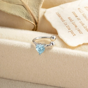 Elegant silver ear bone cuff with heart-shaped blue zircon on a vintage fabric base