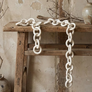 Minimalist cream ceramic decorative link chain in Wabi-sabi style on wooden bench