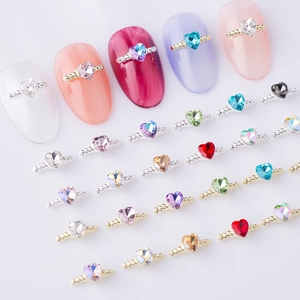 Close-up of heart-shaped nail rhinestones with gold and silver twisted metal bases