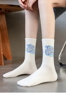 Close-up of white cotton sports socks with blue Young Captain lettering and ribbed cuff