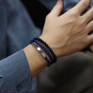 Close-up of three blue multilayer braided leather and beaded bracelets on a male wrist