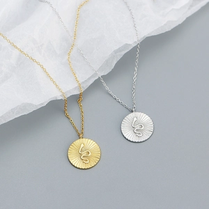 Elegant silver snake pendant necklace set with gold and silver round medallion charms