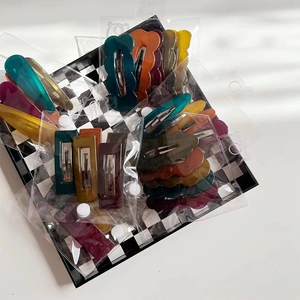 Colorful jelly texture wavy acrylic hair clips in trendy geometric shapes on a tray