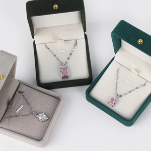 Three silver necklaces with zircon pendants displayed in velvet gift boxes on white background