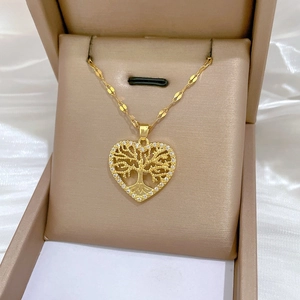 Close-up of golden heart tree of life pendant with sparkling crystals in a gift box