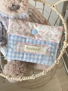 Blue plaid and pink floral storage pouch for sanitary pads with button closure