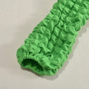 Detailed macro view of green popcorn fabric texture with elastic pleated design