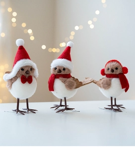Detailed close-up of three plush Christmas birds with festive hats and scarves decoration