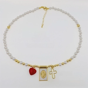 Detail of 18K gold plated copper necklace with pearls, red heart and Virgin Mary pendant