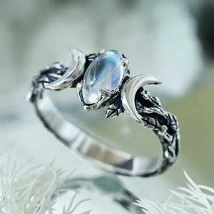 Macro shot of retro moonlight stone ring featuring silver crescents and branch texture