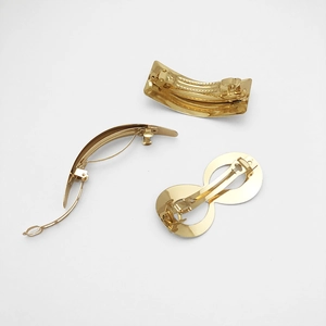 Three-piece gold metal spring hair clips set in rectangular, curved, and figure-eight shapes
