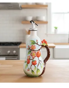 Detail of hand-painted ceramic oil dispenser with persimmon relief and metal pour spout
