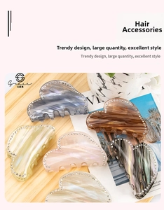 Close-up of heart-shaped marble acetate hair claws with rhinestone edges in six colors