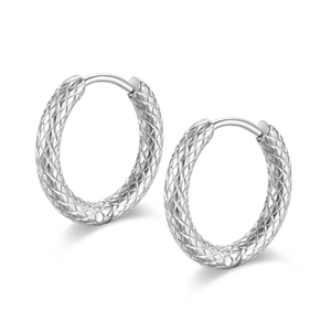 Macro view of silver titanium steel hoop earrings with textured lattice pattern