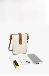 Capacity detail of leather crossbody bag showing phone, power bank, and cosmetics