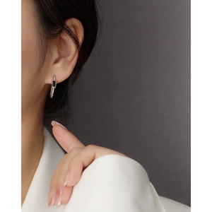 Detail of s925 silver U-shaped earrings with black zircon inlay on a female model